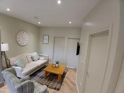a living room with a couch and a table at Castle View 3 bedroom with garden in Dumbarton