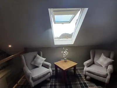 two chairs and a table in a room with a window at Castle View 3 bedroom with garden in Dumbarton
