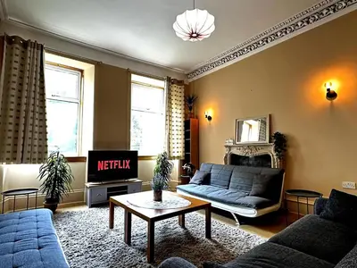 a living room with a couch and a tv at Cheerful 5 Bedroom House Close to Central West End and Parking in Glasgow