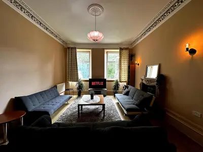 a living room with two blue couches and a table at Cheerful 5 Bedroom House Close to Central West End and Parking in Glasgow