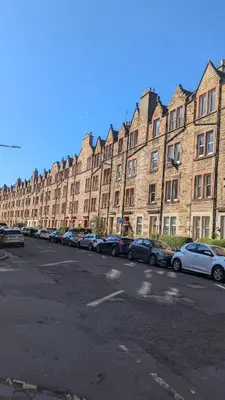 a row of cars parked in front of a large building at 2 Bedroom Flat in Edinburgh City in Edinburgh