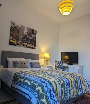 a bedroom with a bed and a flat screen tv at 2 Bedroom Flat in Edinburgh City in Edinburgh