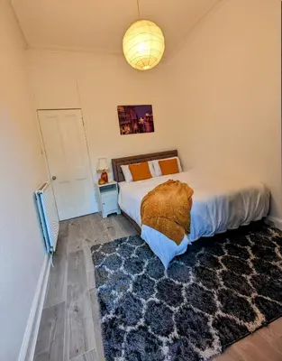 a bedroom with a large bed and a rug at 2 Bedroom Flat in Edinburgh City in Edinburgh