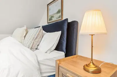 a bedroom with a bed and a lamp on a table at Luxury 2 Bed cottage in Killin in Killin