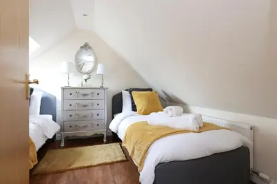 a attic bedroom with two beds and a dresser at Greenknowes Entire Private Estate in Kelty