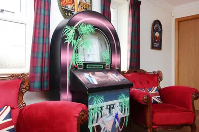 a video game machine in a room with two chairs at Greenknowes Entire Private Estate in Kelty
