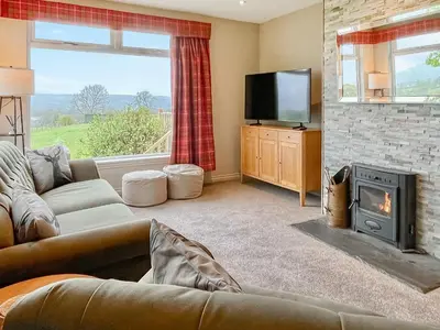 a living room with a couch and a fireplace at Ardvenhor in Gartocharn