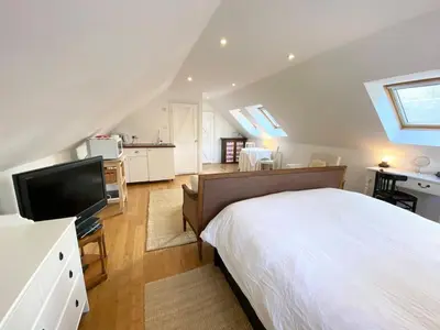 a bedroom with a bed and a television in a attic at Converted Historical Stone Coach House in Glasgow