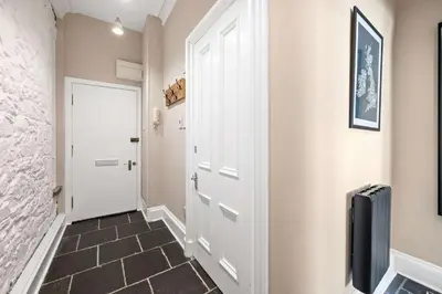a hallway with a white door and a tile floor at Stunning 1Bedroom Central Apartment in Oban