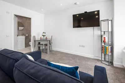 a living room with a blue couch and a table at Modern & Central 1BR Flat with Sky TV in Oban
