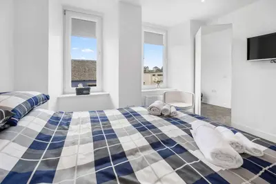 a bedroom with a blue and white bed with towels on it at Modern & Central 1BR Flat with Sky TV in Oban