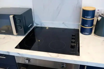 a black microwave sitting on top of a counter at Modern & Bright 2BR Flat - Short Walk to Town in Oban
