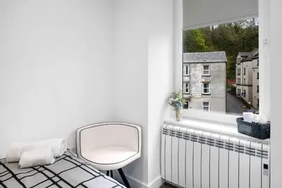 a white room with a mirror and a window at Modern & Bright 2BR Flat - Short Walk to Town in Oban