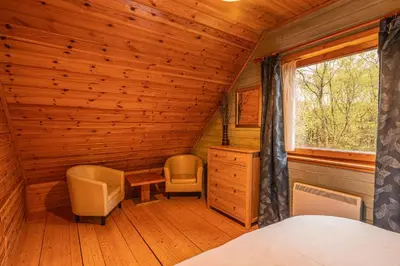 a bedroom with a bed and a desk and a window at Lodge 1 in Stirling