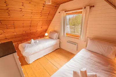 a bedroom with two beds in a wooden room at Lodge 2 in Stirling