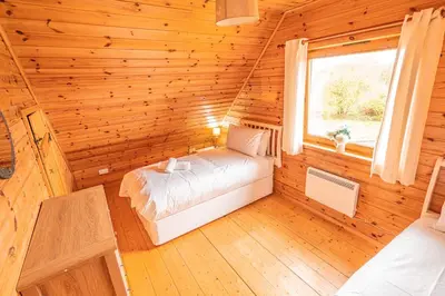 a bedroom with a bed in a log cabin at Lodge 3 in Stirling