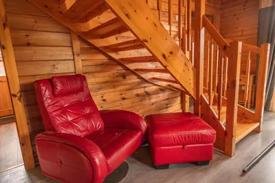 a red chair and a stool in a attic at Lodge 4 in Stirling