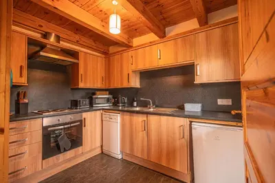 a large kitchen with wooden cabinets and appliances at Lodge 5 in Stirling