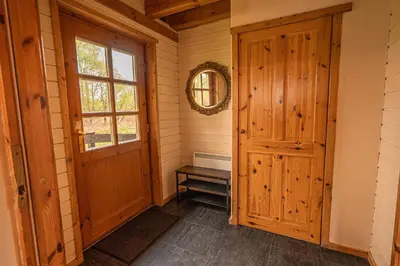 a hallway with a wooden door and a window at Lodge 5 in Stirling