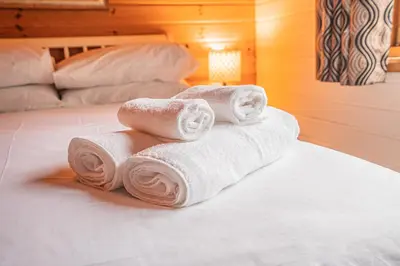 a pile of towels sitting on top of a bed at Lodge 5 in Stirling