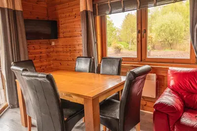 a dining room with a wooden table and chairs at Lodge 5 in Stirling