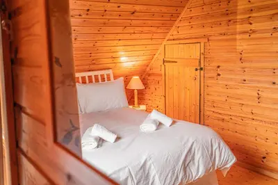 a bedroom with a bed in a wooden cabin at Lodge 6 in Stirling