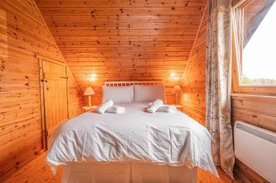 a bedroom with a bed in a wooden cabin at Lodge 6 in Stirling