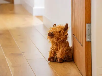 a small brown dog sitting next to a door at The Stables in Thornhill