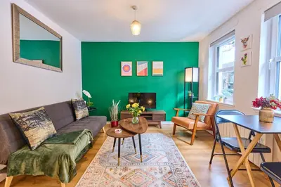a living room with a couch and a green wall at Modern 1BR Apartment - Close to ferry terminal with free parking in Oban