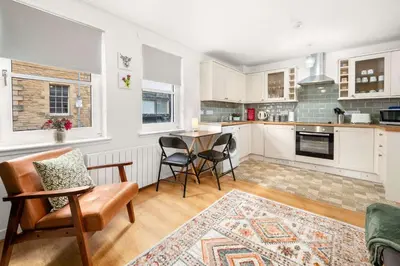 a kitchen with a table and chairs in a room at Modern 1BR Apartment - Close to ferry terminal with free parking in Oban