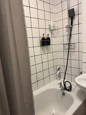 a white tiled bathroom with a sink and a shower at Cozy Central 1 Min to Tube in Moffat