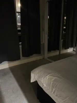 a bedroom with a bed and some windows at Cozy Central 1 Min to Tube in Moffat