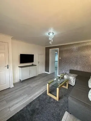 a living room with a couch and a tv at My Glasgow House Robroyston in Hogganfield