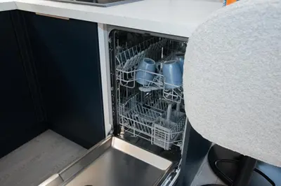 a dishwasher with dishes in it next to a table at The White House near Edinburgh in Bathgate
