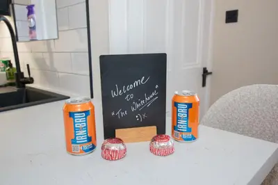 a table with two soda cans and a menu and cupcakes at The White House near Edinburgh in Bathgate