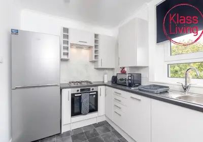 a kitchen with white cabinets and a sink at Sanderson Upper by Klass Living Uddingston in Uddingston