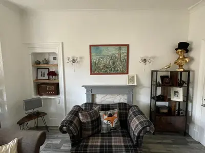a living room with a plaid couch and a fireplace at Isle of Bute Blissful Retreat- Stunning 3 Bed Flat in Rothesay
