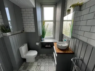 a bathroom with a toilet and a sink and a window at Isle of Bute Blissful Retreat- Stunning 3 Bed Flat in Rothesay