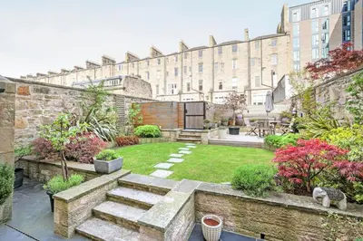 a garden with a large building in the background at Melville Street Townhouse in Edinburgh