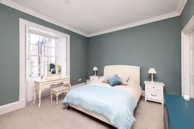 a bedroom with a bed and a desk and a window at Melville Street Townhouse in Edinburgh