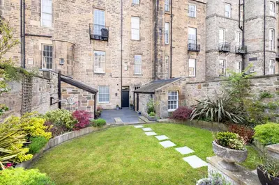 a garden in front of a large brick building at Melville Street Townhouse in Edinburgh
