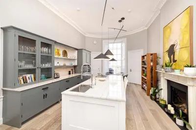 a kitchen with a white counter and a fireplace at Melville Street Townhouse in Edinburgh