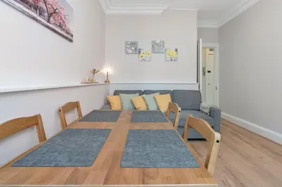 a living room with a table and a couch at Lovely Haymarket Apartment - Central Edinburgh in Edinburgh