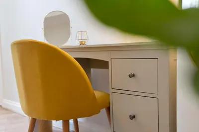 a desk with a yellow chair and a mirror at Lovely Haymarket Apartment - Central Edinburgh in Edinburgh