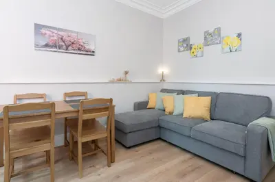a living room with a couch and a table at Lovely Haymarket Apartment - Central Edinburgh in Edinburgh