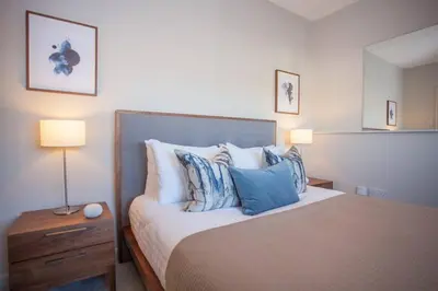 a bedroom with a bed with blue and white pillows at Stylish 2-Bed Apartment Near Glasgow Green in Glasgow