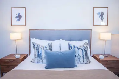 a bed with blue and white pillows and two lamps at Stylish 2-Bed Apartment Near Glasgow Green in Glasgow