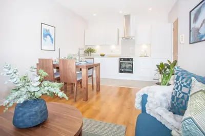 a living room with a blue couch and a table at Stylish 2-Bed Apartment Near Glasgow Green in Glasgow
