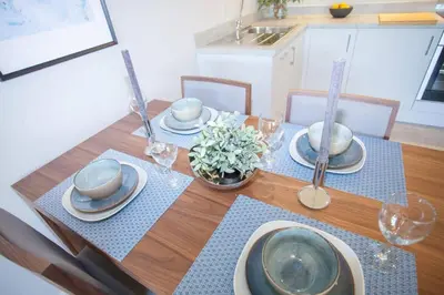 a dining room table with plates and dishes on it at Stylish 2-Bed Apartment Near Glasgow Green in Glasgow