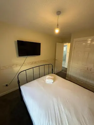 a bedroom with a bed and a flat screen tv at 2-Bed City Apartment by Glasgow Green in Glasgow